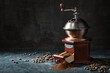 Wooden vintage coffee grinder, roasted beans and ground coffee on a dark rustic background with copy space, selected focus