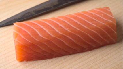 Poster - slicing salmon sashimi with knife on wooden cutting board