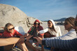 © Daxiao Productions/Stocksy - Beach drinking friends