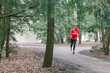 © Ivo de Bruijn/Stocksy - Runner running through the woods on a path
