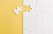 © sorapop - Top view flat lay of paper plain white jigsaw puzzle game texture last pieces for solve and place, studio shot on a yellow background, quiz calculation concept