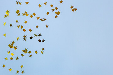 Small gold stars on a blue background. Copy spase