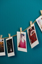Mini Polaroid Pictures Clipped To A String Hang On A Wall