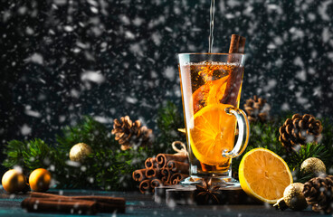 Wall Mural - Christmas or New Year hot winter drink, spicy grog cocktail, punch or mulled wine with tea, lemon, rum, cinnamon, anise under the snow