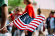 © Gabriel (Gabi) Bucataru/Stocksy - USA Flag Waved at A National Holiday Parade