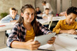 © Drazen - Happy schoolgirl using digital tablet during a class in the classroom.