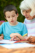 © Lee Avison Photography/Stocksy - senior woman helping a young boy with his school work