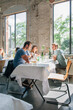 © VISUALSPECTRUM/Stocksy - Young People Talking Over Drinks in a Trendy Restaurant