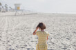 © Goodness Grace Photography/Stocksy - Back of girl wearing yellow dress on beach