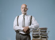 © stokkete - Confident businessman posing with a pile of paperwork