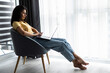 © F8  \ Suport Ukraine - Young woman sitting on chair with laptop working at home