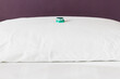 © Gourmet Photography/Stocksy - Green wrapped mint chocolates on a white pillow in a hotel