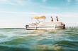 © HOWL/Stocksy - Friends hanging out on a pontoon boat in the ocean