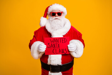 Poster - Portrait of his he nice attractive bad Santa disguise hardened criminal holding in hands red board wanted search seeking isolated over bright vivid shine vibrant yellow color background