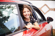 © Guille Faingold/Stocksy - Cheerful girl looking out of car