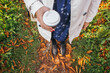© Jovo Jovanovic/Stocksy - Trendy girl stands in colorful autumn leaves and drinking coffee