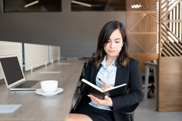 Businesswoman updating her business diary