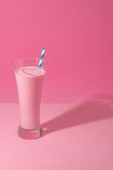 Wall Mural - glass of strawberry smoothie on pink background