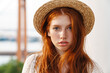 © Drobot Dean - Image of young ginger girl in straw hat smiling and looking at camera