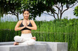 © anon - Portrait of young woman practicing yoga in garden.female happiness. blurred background.Healthy lifestyle and relaxation concept.Young Asian Girl doing yoga in the park.