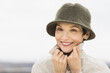 © Tetra Images - Portrait of smiling woman wearing raincoat and hat