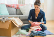© Jamie Grill/Tetra Images - Woman packing clothes to box