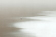illustration of lonely man walking in the sand looking at the calm sea, surreal minimal seascape