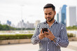 © Ranta Images - Young bearded Indian businessman relaxing at the park in the cit