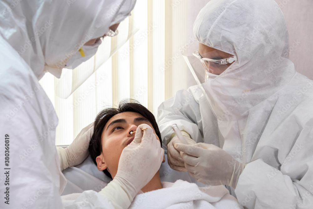 male nurse and doctor wearing ppe suit and facemask perform Coronavirus ...