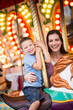 © Mike Kemp/Tetra Images - Mother and son (4-5) on carousel in amusement park