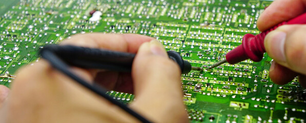 Electronics repair with tester.Repair technician test On an electronic board.