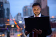 © Ranta Images - Young bearded Indian businessman against view of the city at nig