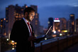 © Ranta Images - Young bearded Indian businessman against view of the city at nig