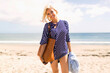 © Tetra Images - Woman wearing striped blouse posing on sandy beach