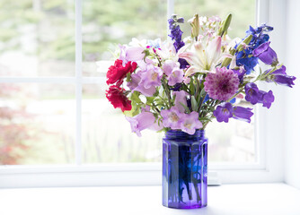 Original photograph of a beautiful flower bouquet in a cobalt blue glass vase sitting in a bright white sunny windowsill