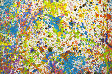 Multicoloured Paint Splatters On A White Wall