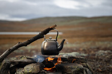 Camp Kettle Is Heated On A Bonfire. Hiking, Travel In The Mountains. Outdoor Recreation Concept. Lapland.