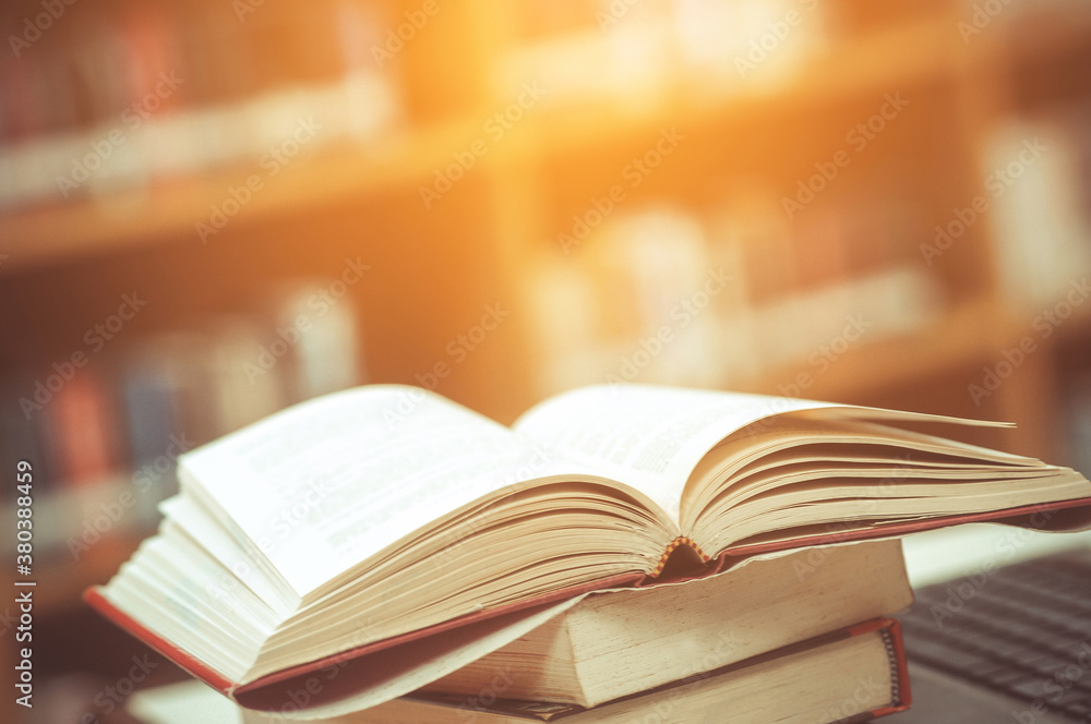Book stack in the library and blurred bookshelf background for ...