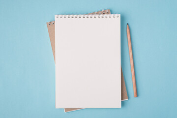 Top above overhead view flat lay  photo of a blank notebook and a pencil beside isolated on pastel blue color background with copyspace