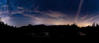 A panoramic view of Tarn Hows with the milky way & the plough in the cloudy night sky