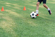 © gorynvd - Soccer player kicking ball on field. Soccer players on training session. Close up footballer feet kicking ball on grass.
