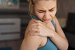 © brillianata - Women wearing athletic suits feeling shoulder pain after exercise at home. The danger of self-training