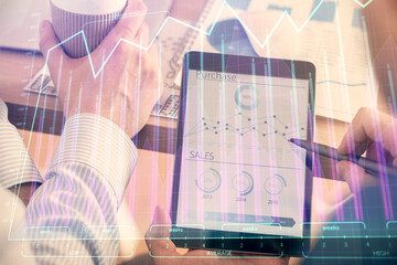 Double exposure of man's hands holding and using a phone and financial chart drawing. Market analysis concept.