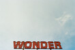 © Austin Rogers/Stocksy - Wonder'' Sign Against Blue Sky and Clouds