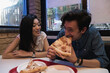 © Eddie Pearson Photography/Stocksy - Cute mixed couple laughing and eating pizza
