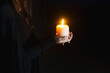 © Tana Teel Photography/Stocksy - person holding lit candle in the dark