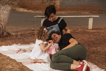 Wall Mural - couple of women having fun with daughter outdoors