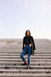 © Marija Kovac/Stocksy - Stylish woman standing on the stairs - vertical