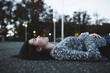 © Rob and Julia Campbell/Stocksy - Young black haired woman lying down on sidewalk
