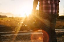 Wild, Young And Free - Detail Of A Biker Holding His Helmet Watching The Sunset